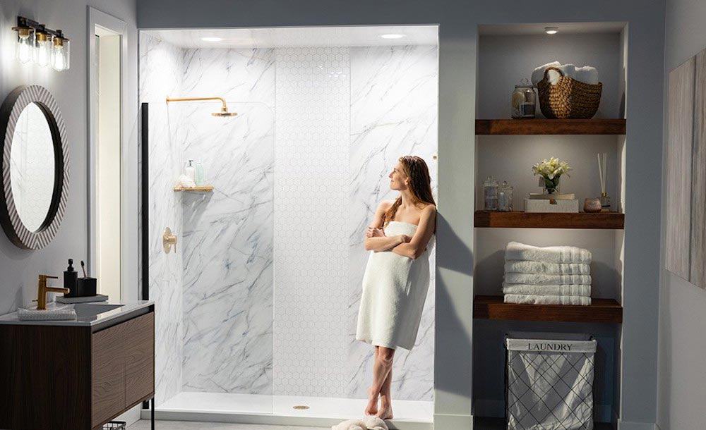 Bathroom remodel shot with woman standing in a towel admiring her shower