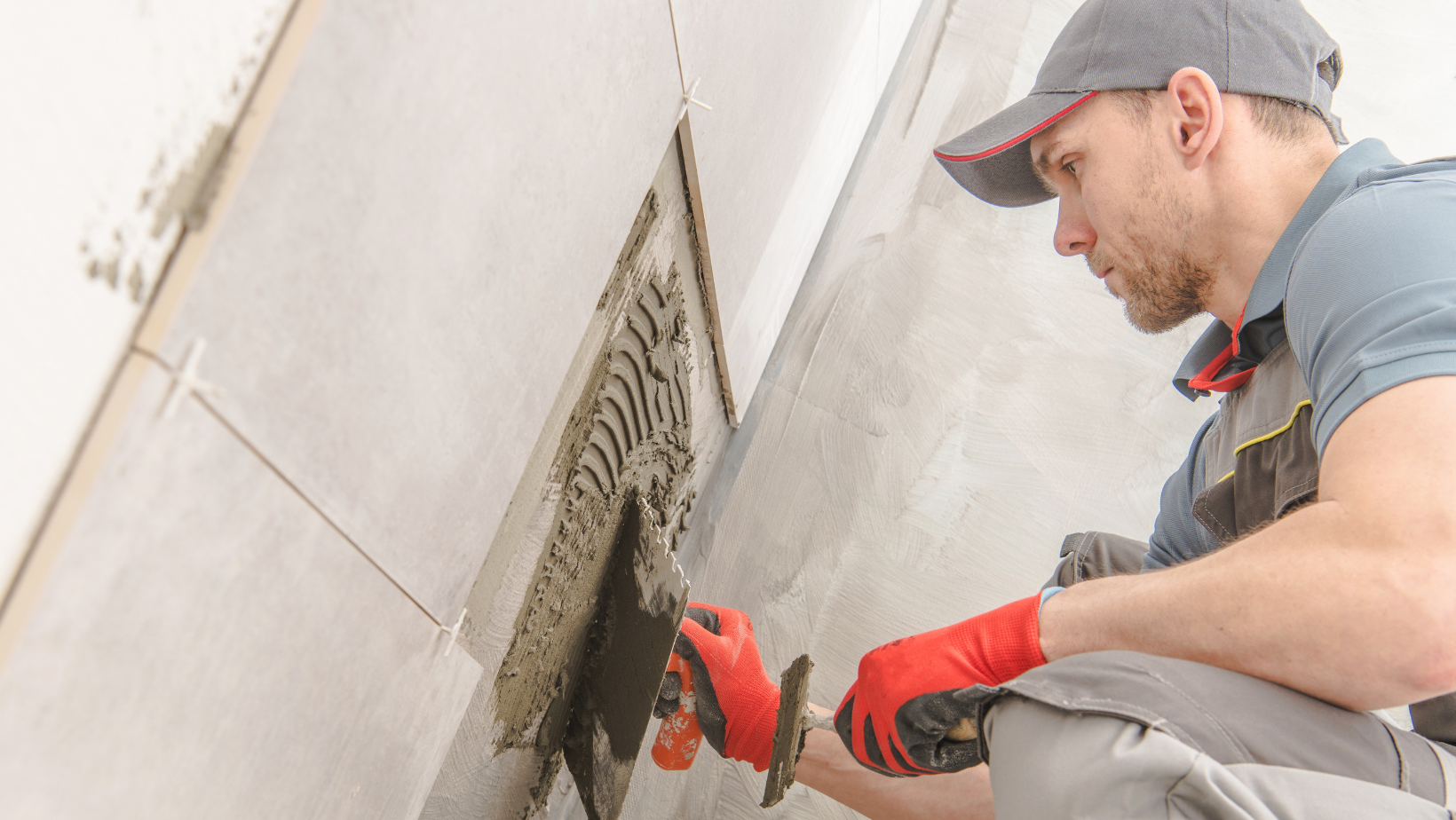 Male contractor working on the grout in a bathroom remodel potentially a subcontractor